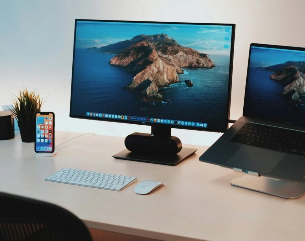 monitor e notebook sobre a mesa