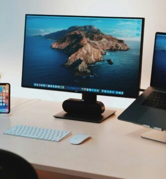 monitor e notebook sobre a mesa